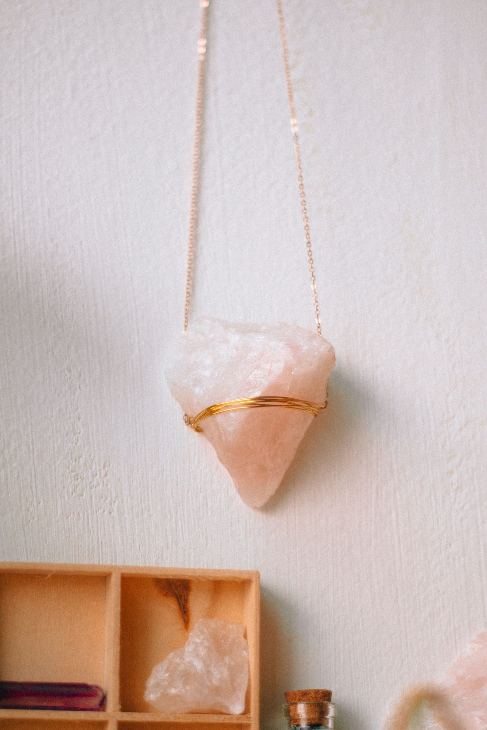 Rose quartz pendant with its natural texture and gold-colored wire detail