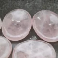May include: Five smooth, pink rose quartz coasters. The coasters are oval shaped and have a slightly concave center.