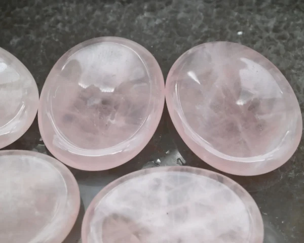 May include: Five smooth, pink rose quartz coasters. The coasters are oval shaped and have a slightly concave center. May include: Five smooth, pink rose quartz coasters. The coasters are oval shaped and have a slightly concave center.