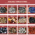 May include: A collection of tumbled stones, including hematite, howlite, labradorite, lapis lazuli, leopard skin jasper, mookaite, moonstone, obsidian, onyx, petrified wood, rainbow moonstone, and red jasper. The stones are arranged in a grid on a wooden surface.