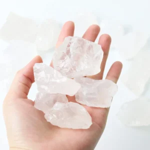 Raw clear quartz stones held in hand