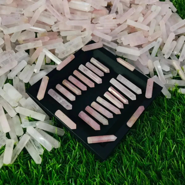 May include: A black tray filled with 20 pink rose quartz points. The points are arranged in rows and are all approximately the same size. The tray is sitting o May include: A black tray filled with 20 pink rose quartz points. The points are arranged in rows and are all approximately the same size. The tray is sitting on a bed of green grass.