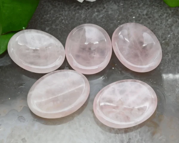 May include: Five smooth, oval-shaped rose quartz stones, polished to a high shine. The stones are pale pink and translucent, with a slight shimmer. May include: Five smooth, oval-shaped rose quartz stones, polished to a high shine. The stones are pale pink and translucent, with a slight shimmer.